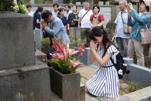 写真：芥川龍之介の墓前で合掌する参加者