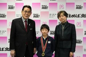 受賞した川口洋翔さんと花川区長（左）、本間教育長職務代理者（右）