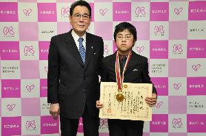 花川区長（左）と受彰した小西健太郎くん（右）